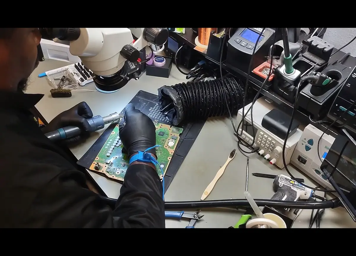 Technician performing hot air rework on a circuit board at the Zidra micro-soldering station