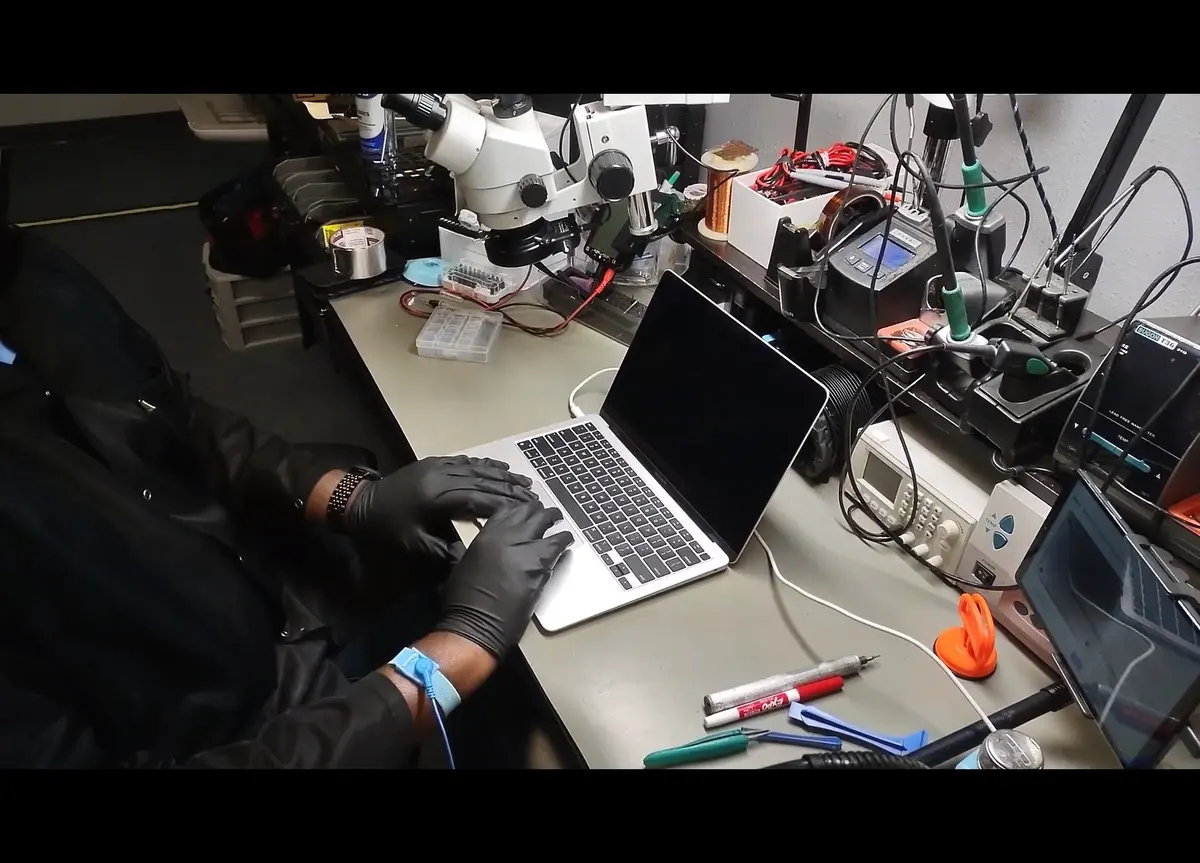 Technician diagnosing a MacBook at the Zidra repair bench